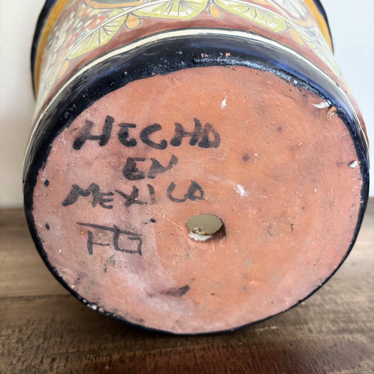 Handmade Talavera pottery with 'Hecho en Mexico' text on a wooden surface